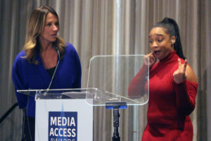 Treshelle Marie Edmond with interpreter behind podium