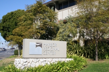 A sign outside the Harbor Regional Center with the center's logo