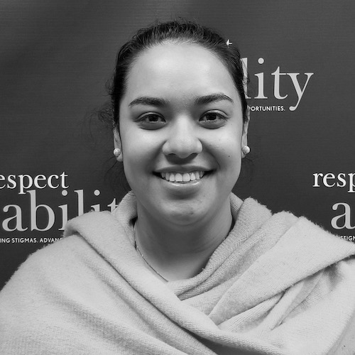 RespectAbility fellow Juliet Arcila Rojas smiling in front of the RespectAbility banner