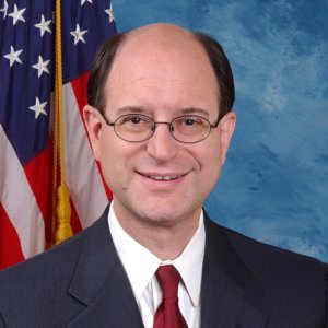 Rep. Brad Sherman smiling in front of an American flag