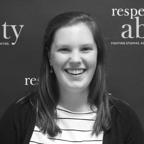 RespectAbility Fellow Emily Counts smiling in front of the RespectAbility banner