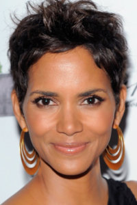 Halle Berry headshot smiling facing the camera with gold hoop earrings