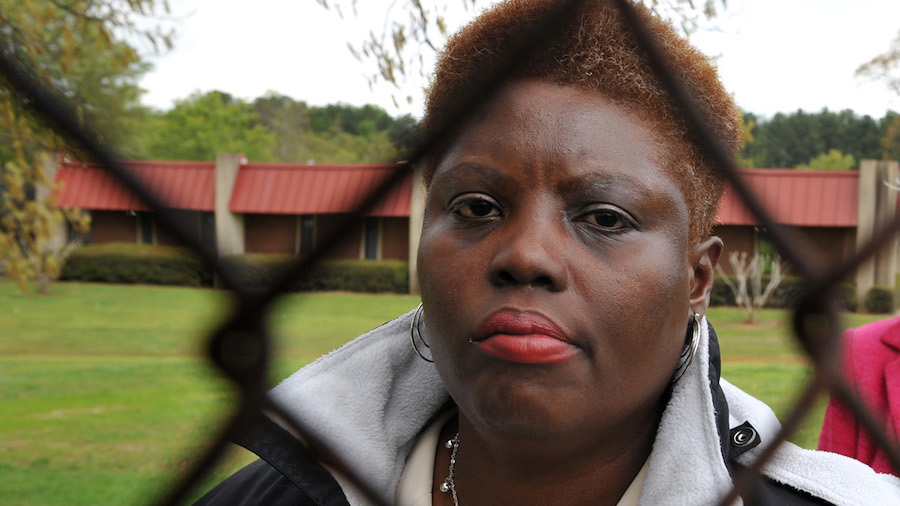 Lois Curtis standing behind a chain-link fence