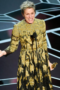 Frances McDormand holding an Oscar giving a speech on stage