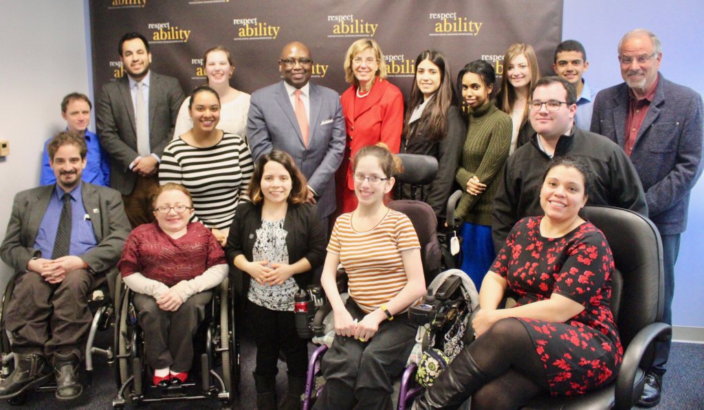 Rodney Hood with RespectAbility Staff and Fellows in front of the RespectAbility banner