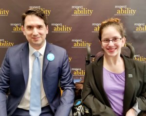 Geoffrey Melada and RespectAbility Fellow Sarah Bram in front of the RespectAbility banner