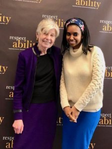 Eleanor Clift and RespectAbility Fellow Tameir Yeheyes smiling in front of the RespectAbility banner