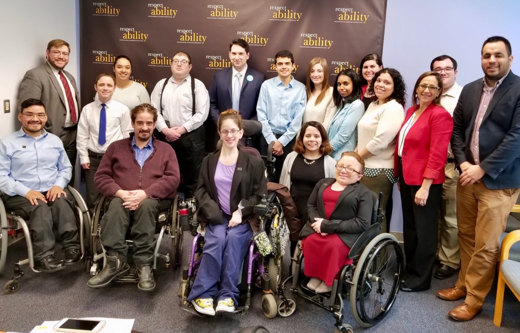 Geoffrey Melada with RespectAbility Staff and Spring 2018 Fellows in front of the RespectAbility banner