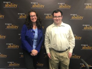RespectAbility Board Member Dana Marlowe and RespectAbility Fellow Eric Ascher smiling in front of the RespectAbility banner