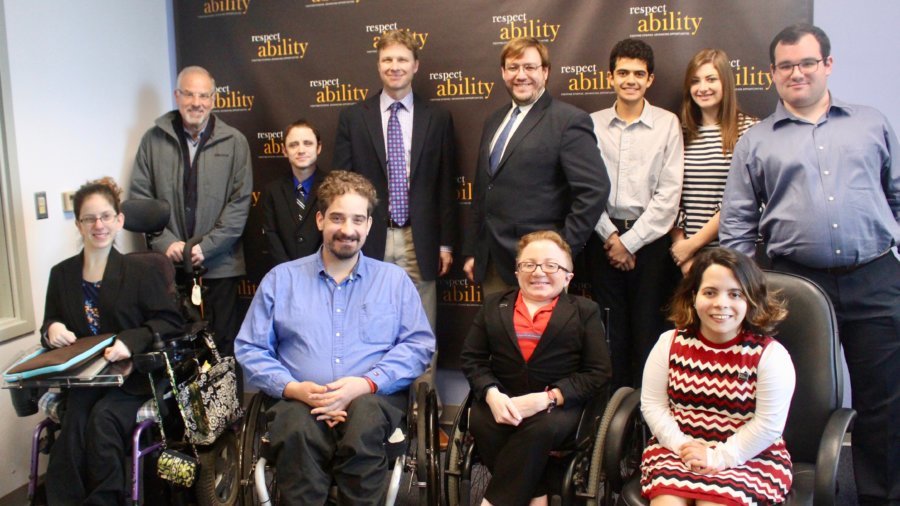 Derek Shields with RespectAbility staff and Fellows in front of the RespectAbility banner