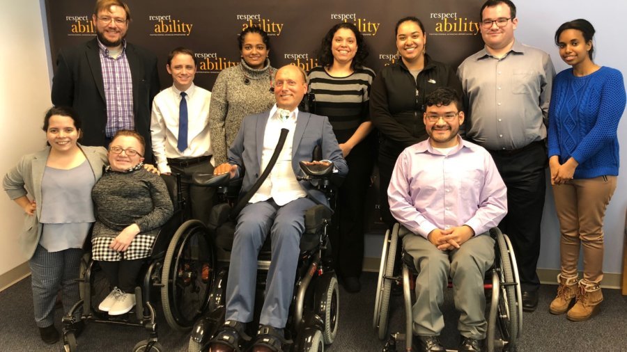 Lenny Larsen with RespectAbility staff and Fellows in front of the RespectAbility banner