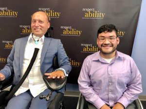 Lenny Larsen and RespectAbility Fellow Steve Bobadilla in front of the RespectAbility banner