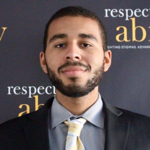 Rami Jackson smiling in front of the RespectAbility banner