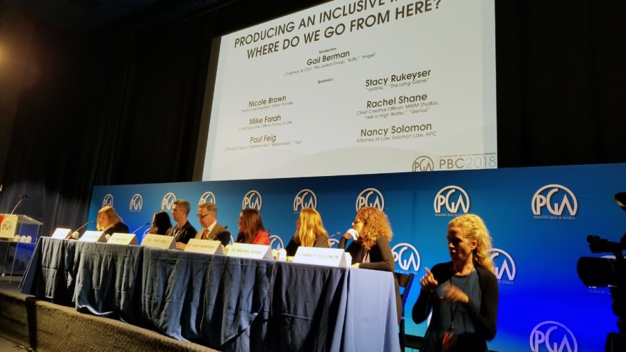 Members of the inclusion panel seated behind a table while an ASL interpreter is in lower right corner