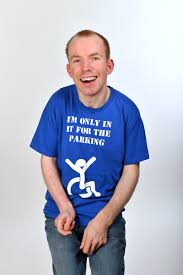 Lee Ridley wearing shirt saying "I'm only in it for the parking" against white background