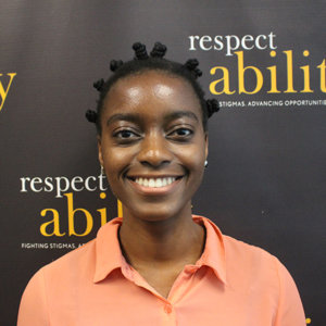 Victoria Grace Assokom-Siakam is smiling in front of the RespectAbility banner