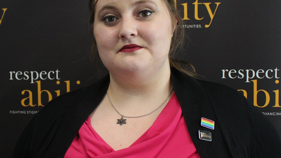 Headshot of Lily in professional dress in front of RespectAbility banner