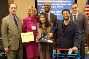 Aaron Kaufman and Vivian Bass accept flag shown in honor of RespectAbility Treasurer Ronald Glancz