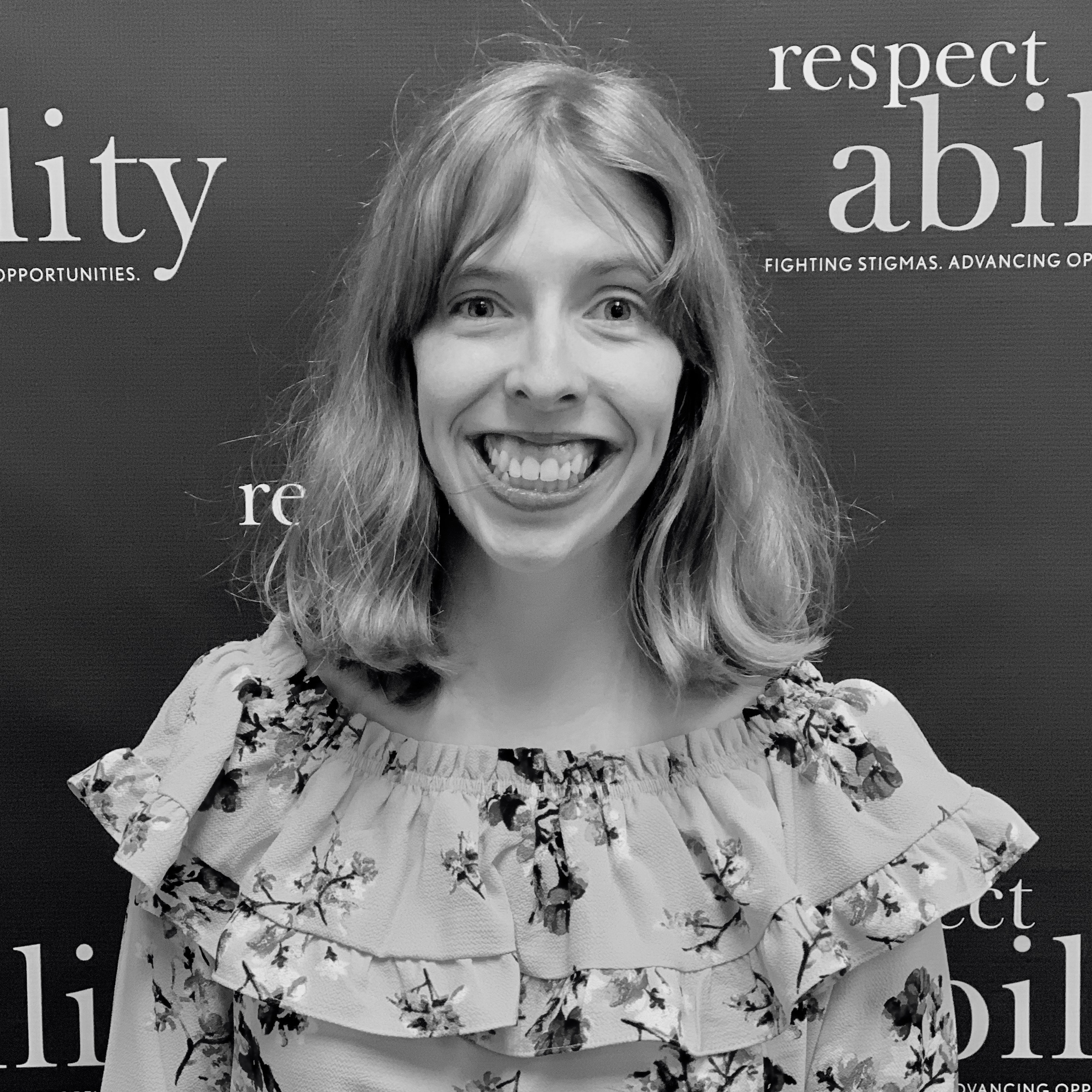 Emily Kranking smiling in front of the RespectAbility banner