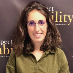 Margot Pitois smiling in front of the RespectAbility banner