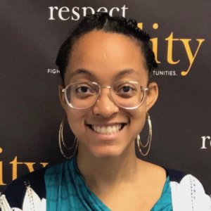 Naya Rhodes smiling in front of the RespectAbility banner