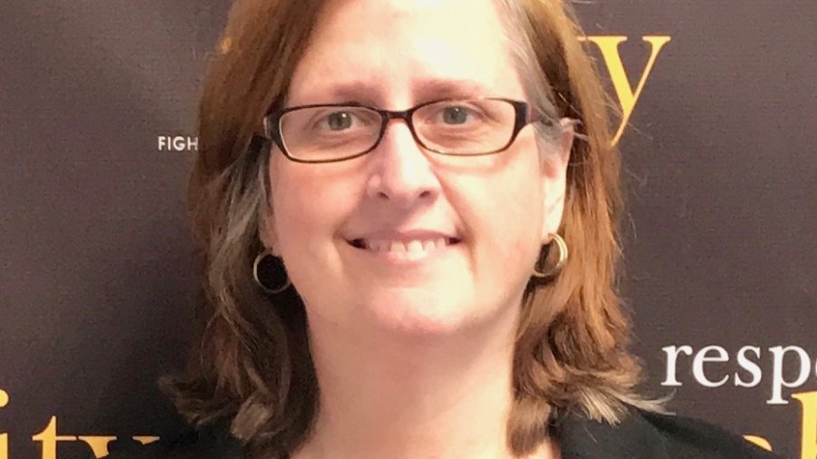 Kathleen L. Brockway smiling in front of the RespectAbility banner