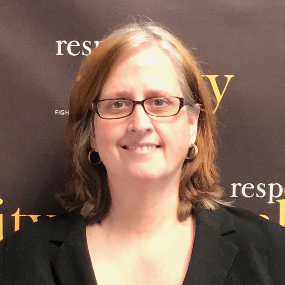 Kathleen L. Brockway smiling in front of the RespectAbility banner