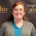 Emma Content smiling in front of the RespectAbility banner