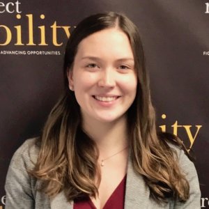 Laura Haney smiling in front of the RespectAbility banner