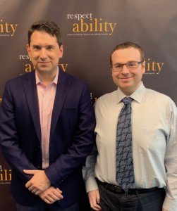 Geoffrey Melada and RespectAbility Fellow Josh Goodrich in front of the RespectAbility banner