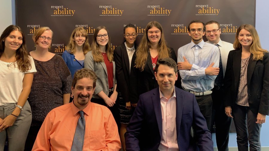 Geoffrey Melada and RespectAbility staff and Fellows in front of the RespectAbility banner