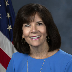 Mary Lazare smiling in front of an American flag