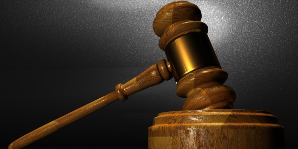 A wooden gavel hitting a circle raised on a desk