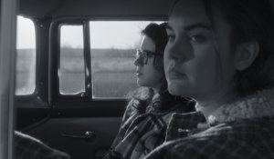Kara Hayward and Liana Liberato sitting in a vehicle