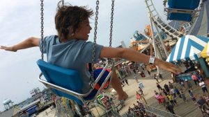 A young girl on a giant swing ride at an amusement park