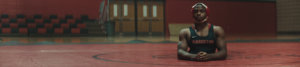 Zion in uniform on the mat in the gym