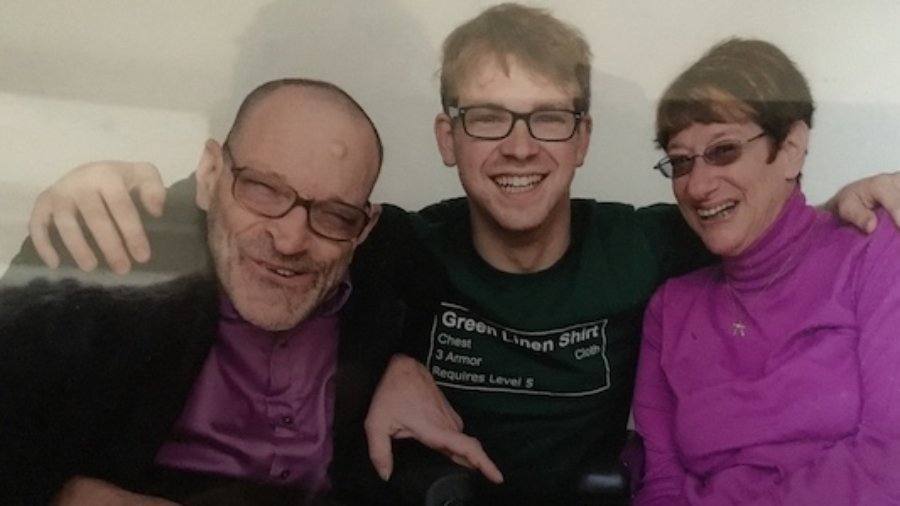 L-R: Neil Jacobson, David Jacobson and Denise Jacobson smiling together. David has his arms around Neil and Denise.