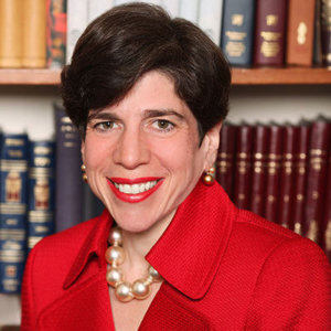 Rabbi Julie Schonfeld in front of a bookcase, smiling