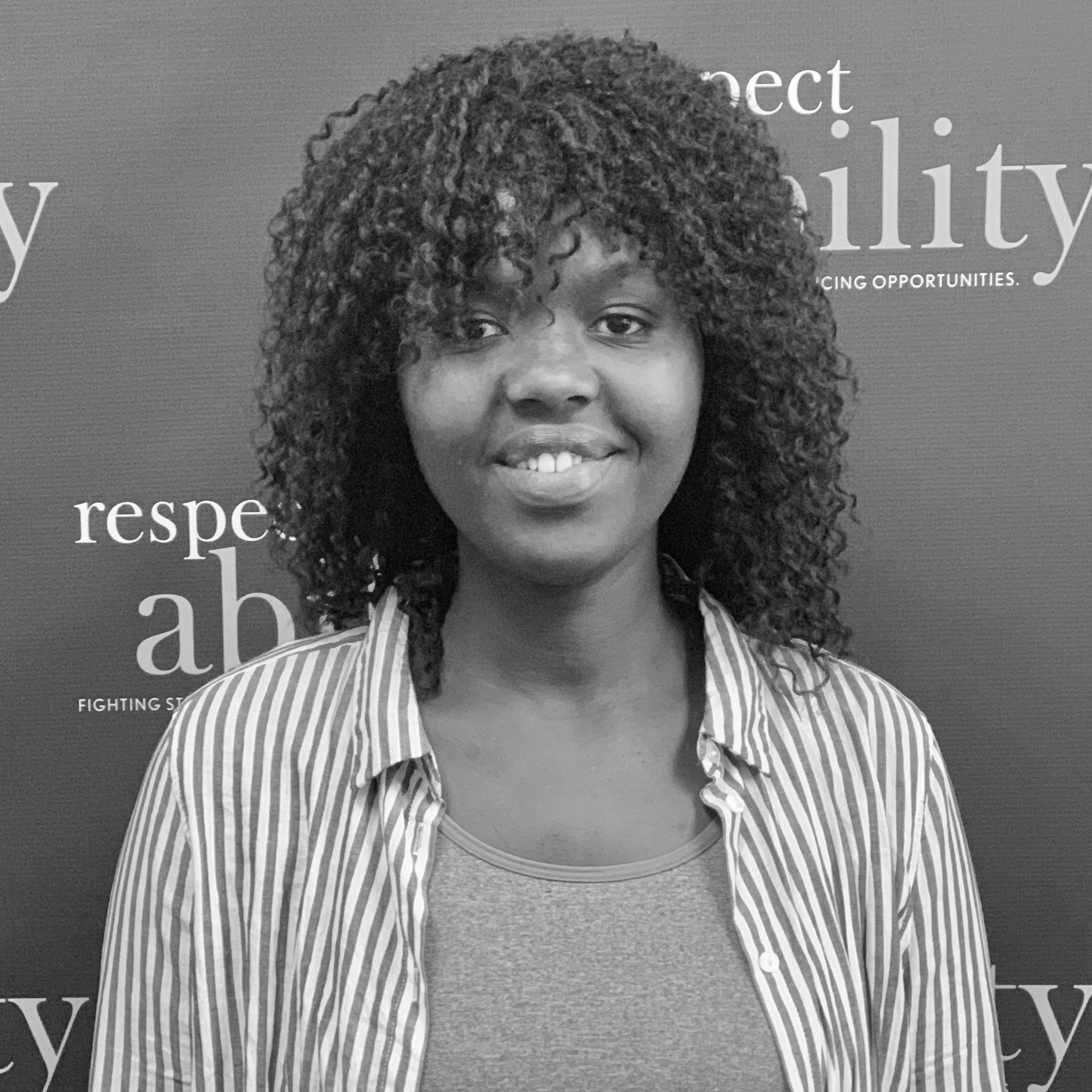 Angelique Uwabera smiling in front of the RespectAbility banner