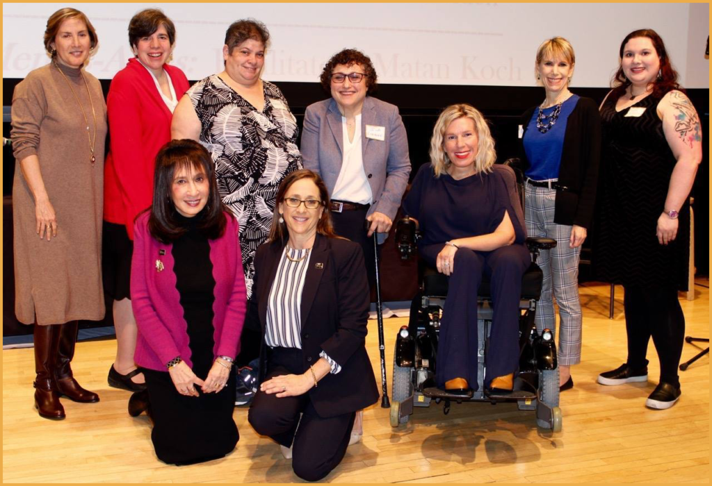 Jewish event presenters smiling together on stage at the JCC Manhattan