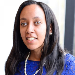 Haben Girma wearing a blue dress and pearls