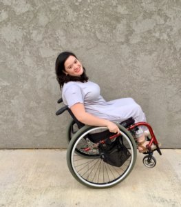 Cami Howe smiling, leaning back in her wheelchair