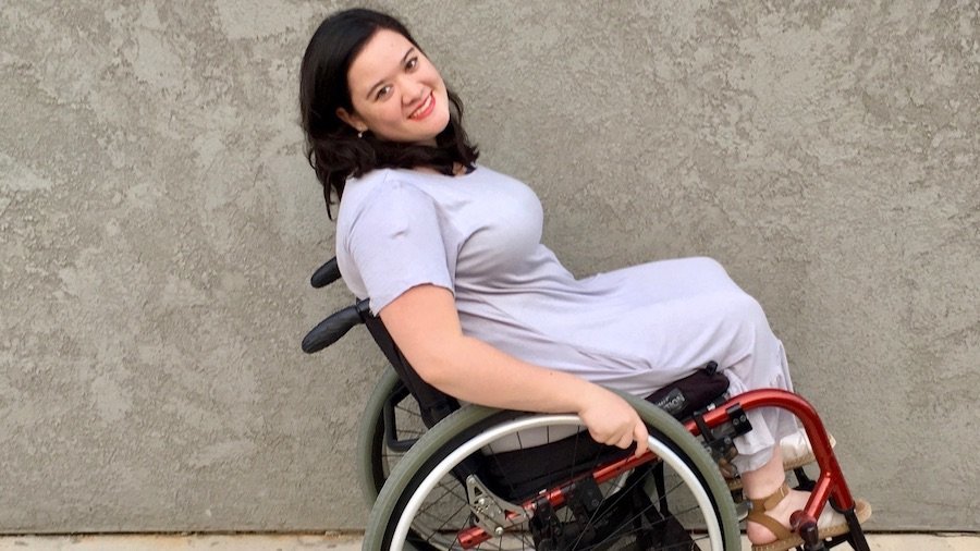 Cami Howe smiling, leaning back in her wheelchair