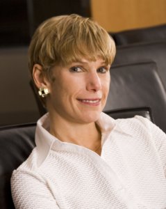 Lori Golden smiling, sitting on a black leather chair