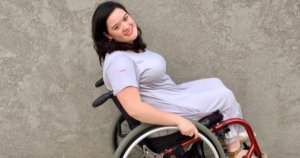 Cami Howe smiling, leaning back in her wheelchair