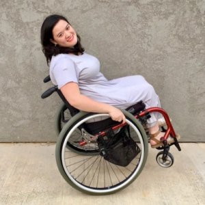 Cami Howe smiling, leaning back in her wheelchair