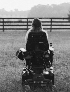 Ariella Barker (from behind) looking at a forest outside. Ariella is using a wheelchair