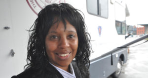 Janet Labreck smiling in front of the New England Eye Mobile Care Clinic