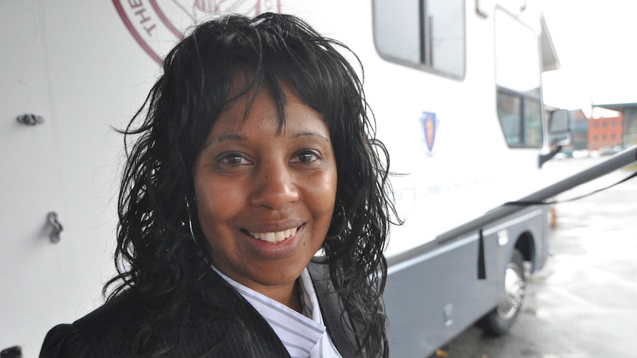 Janet Labreck smiling in front of the New England Eye Mobile Care Clinic