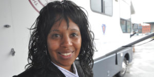 Janet Labreck smiling in front of the New England Eye Mobile Care Clinic